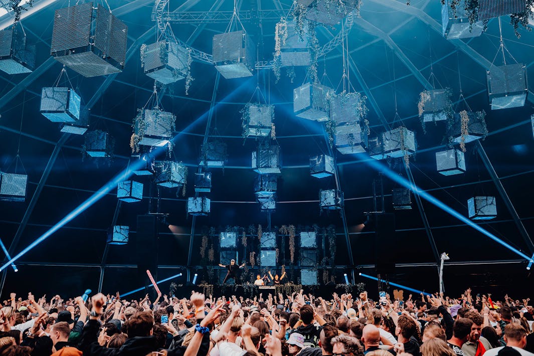 Festivalsfeer bij overdekte stage met blauwe vierkante blokken